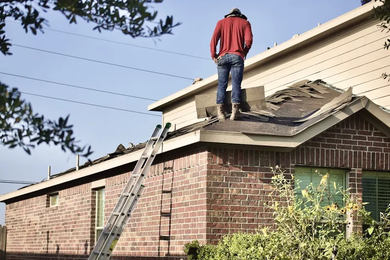 Professional roofer working on a residential roof in Dennis